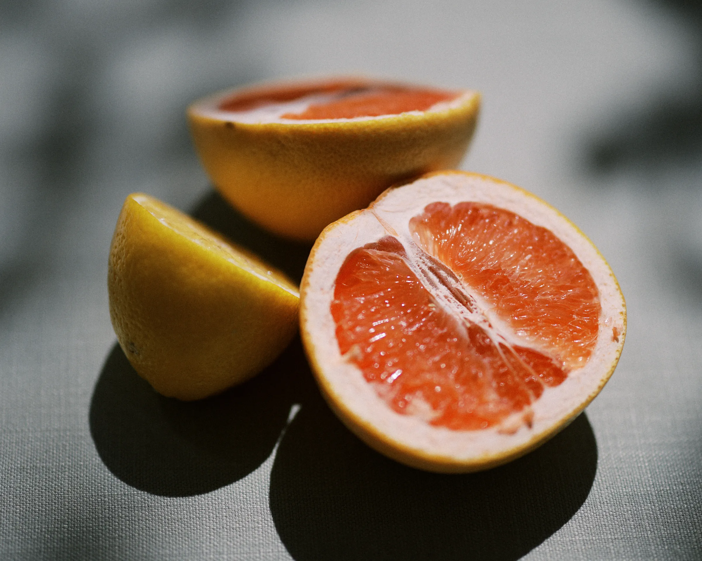 Halved grapefruits in dappled light