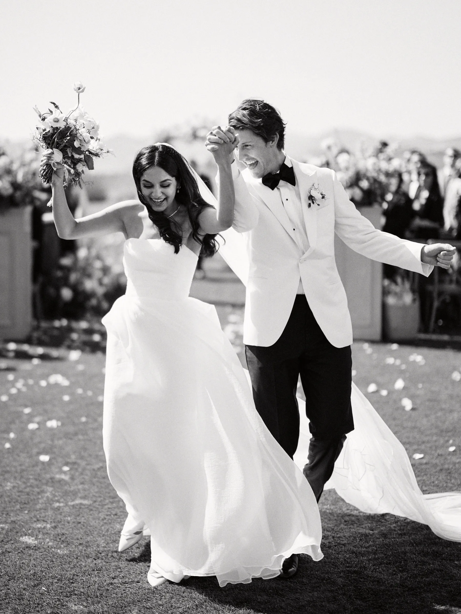 The couple celebrating up the aisle, in black and white