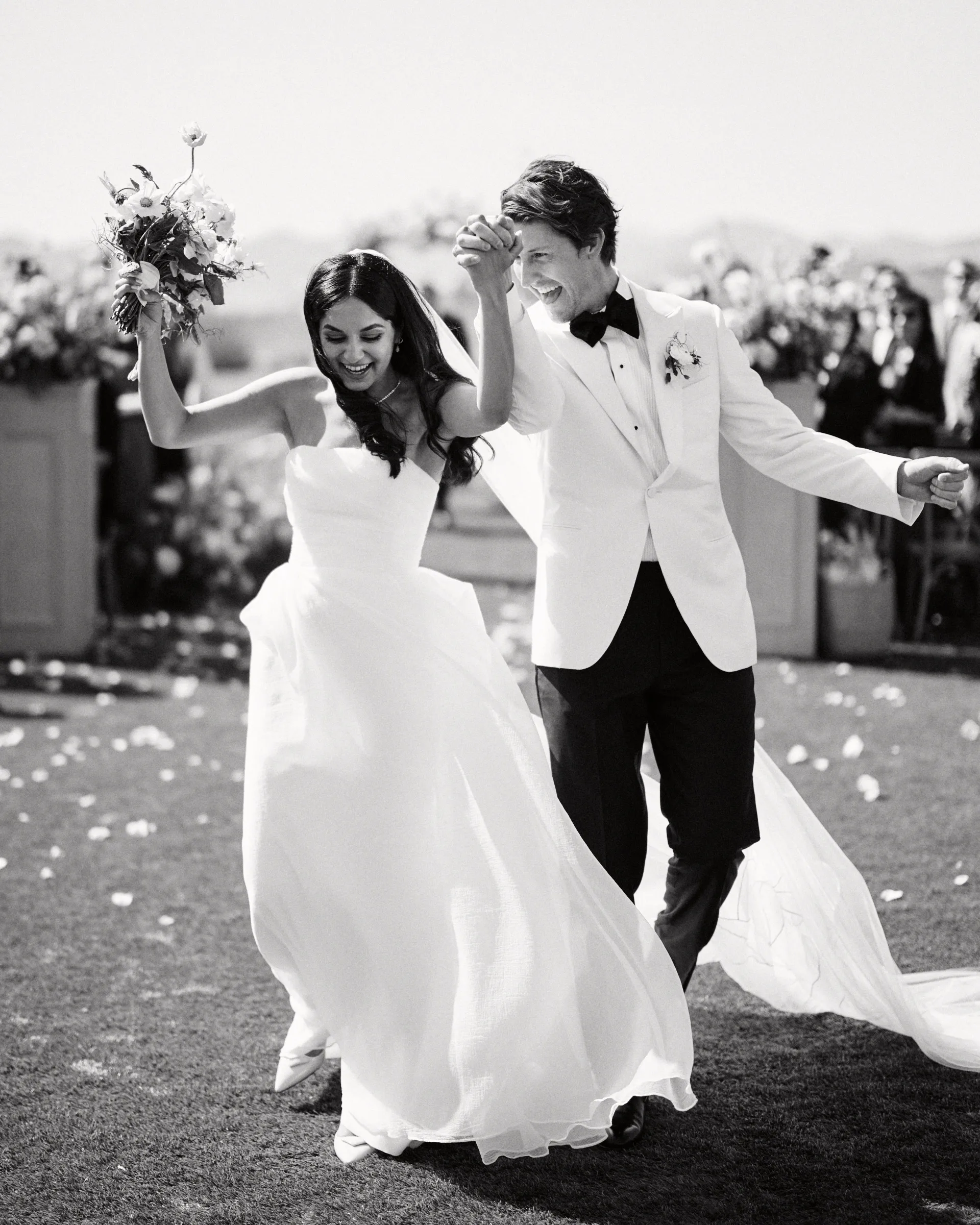 The couple celebrating up the aisle, in black and white