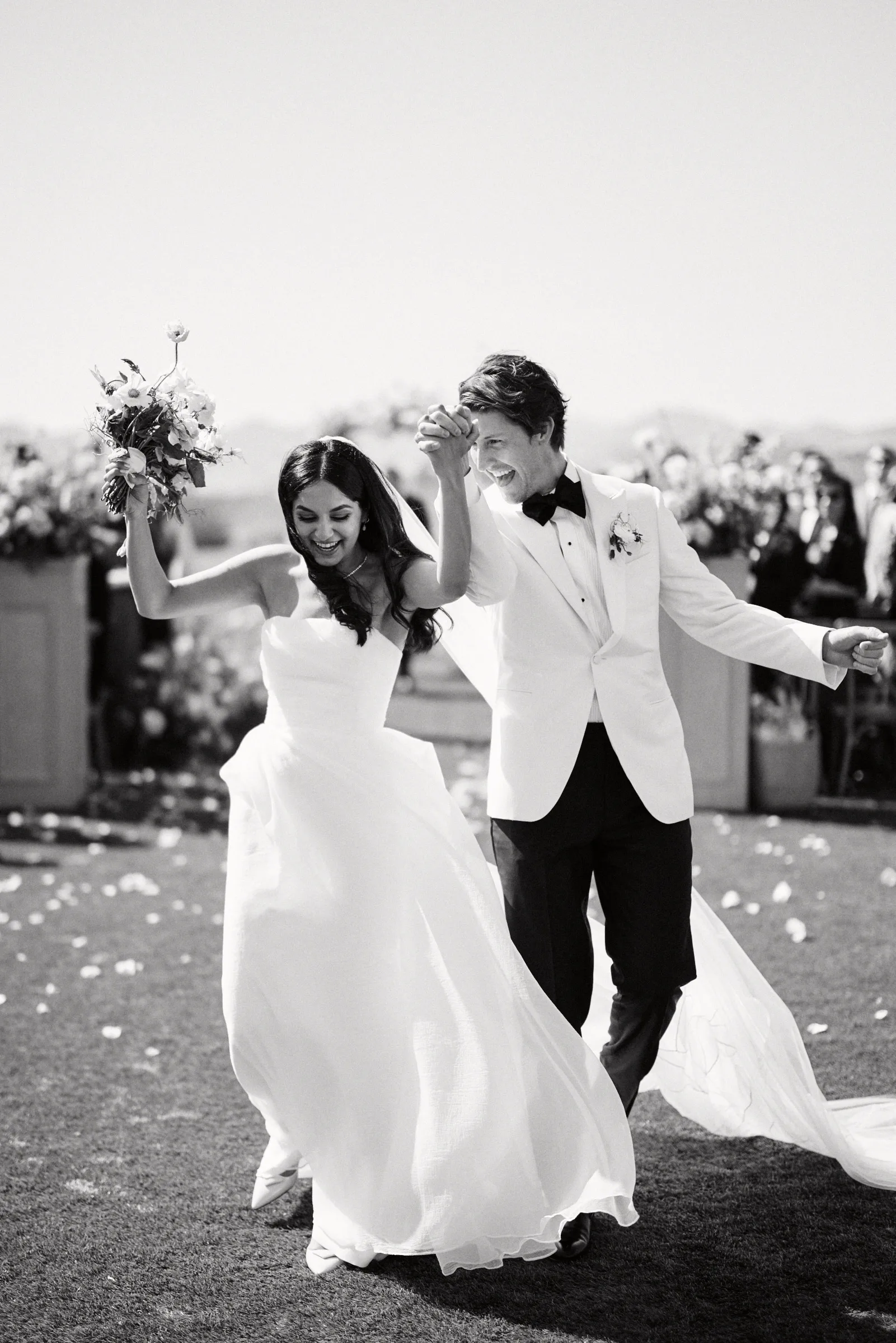 The couple celebrating up the aisle, in black and white